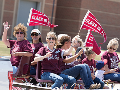 Alumni riding a float in homecoming parade 